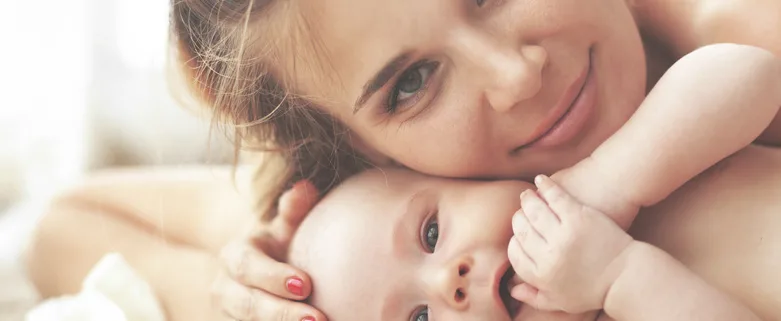 Mère allongée souriant contre son bébé