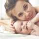 Mère allongée souriant contre son bébé