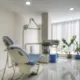 Cabinet dentaire avec fauteuil bleu, lampe et fenêtre à stores verticaux