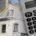 Immeuble en construction avec échafaudage, calculatrice et plan de maison au premier plan