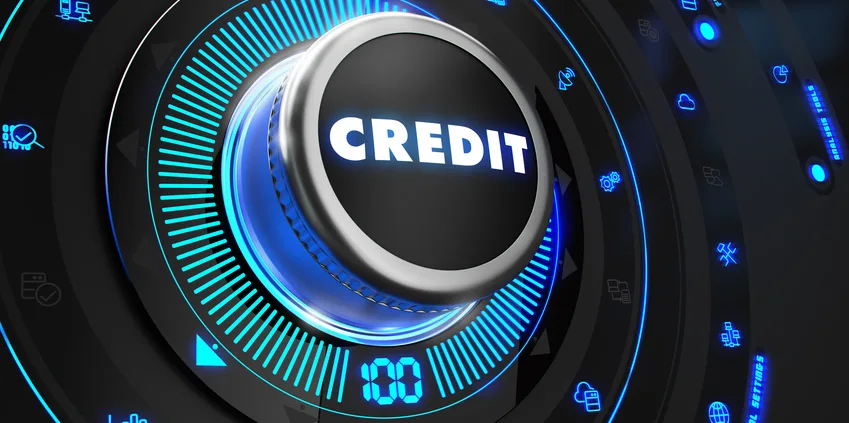 Bouton rotatif lumineux bleu marqué Credit sur une console noire