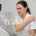 Soignante en blouse blanche, assise près d'un fauteuil dentaire, se tenant l'épaule avec une grimace de douleur